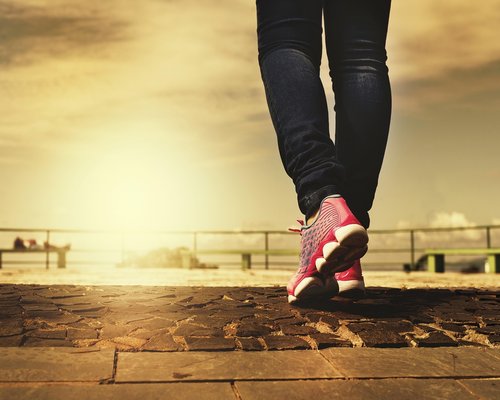 A pair of comfortable walking shoes on an outdoor pavement during sunset